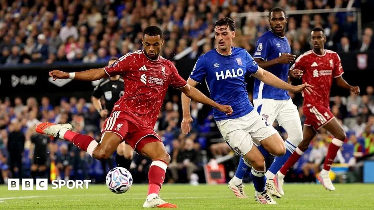 Liverpool player shooting while Ipswich defenders approach