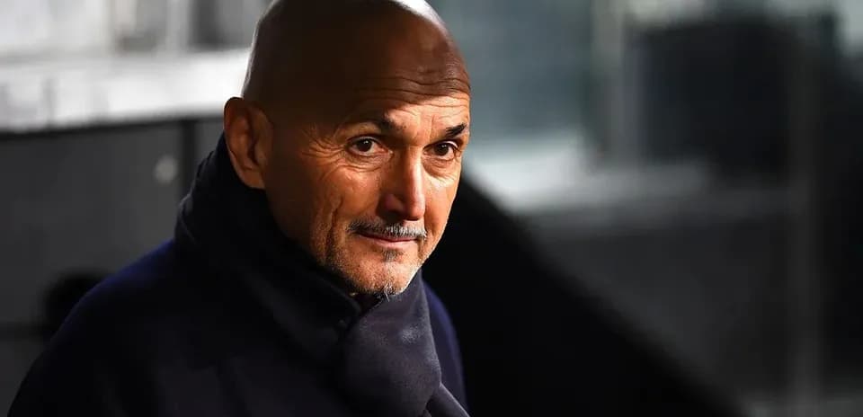Coach wearing a dark scarf, looking thoughtfully