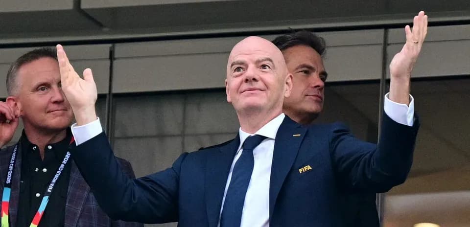 FIFA president gesturing in a VIP box