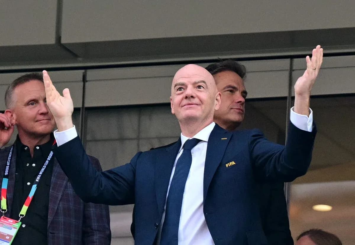 FIFA president gesturing in a VIP box
