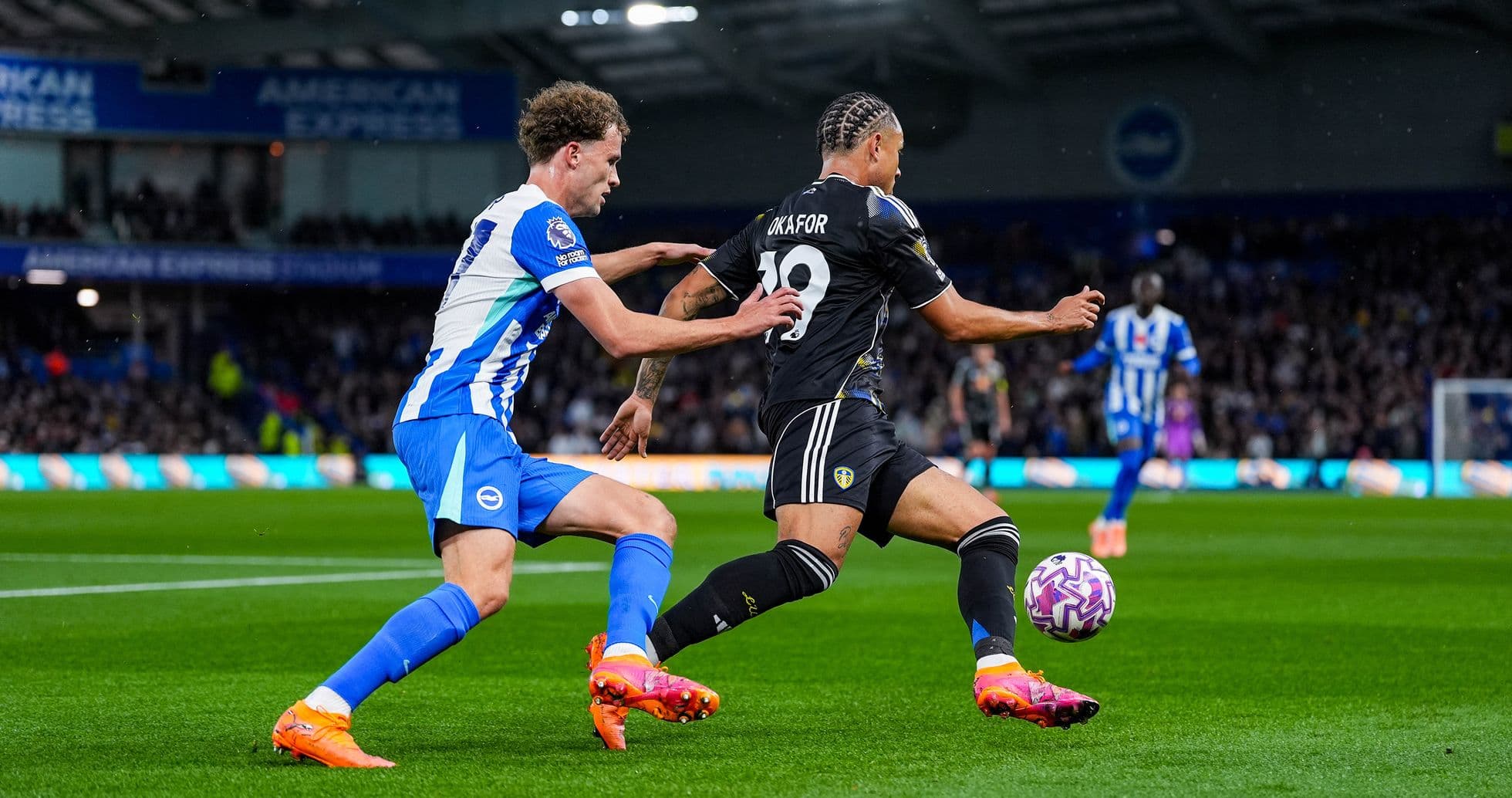 Leeds player challenging Brighton opponent during match