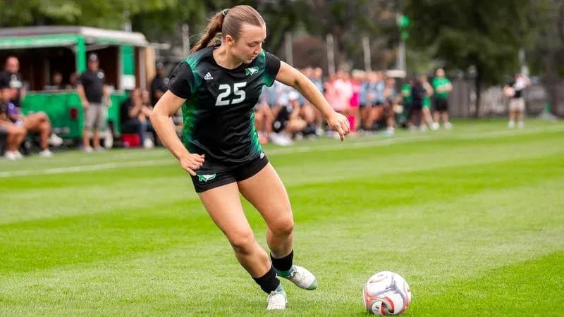 Player 25 kicking soccer ball during match