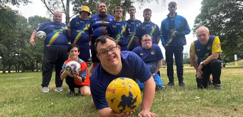 Group of soccer players posing on grassy field