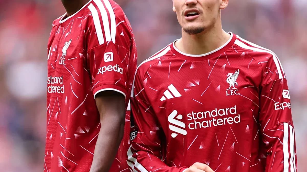 Two Liverpool players in red jerseys on pitch