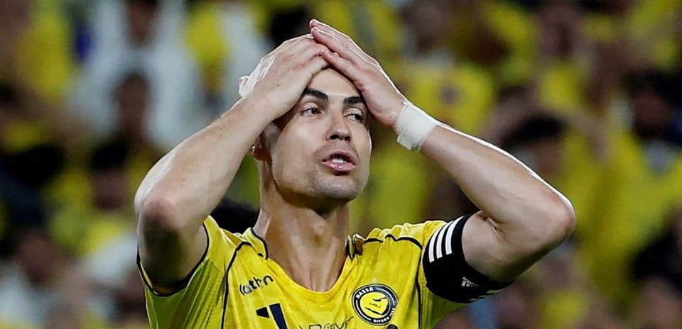 Player in yellow jersey holding head in frustration