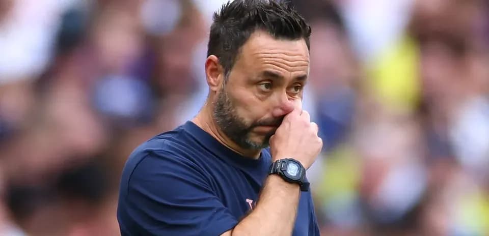 Coach observing game while touching his face