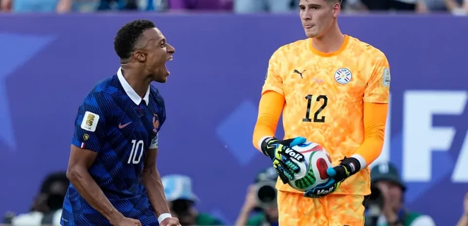 French player celebrating next to Paraguayan goalkeeper