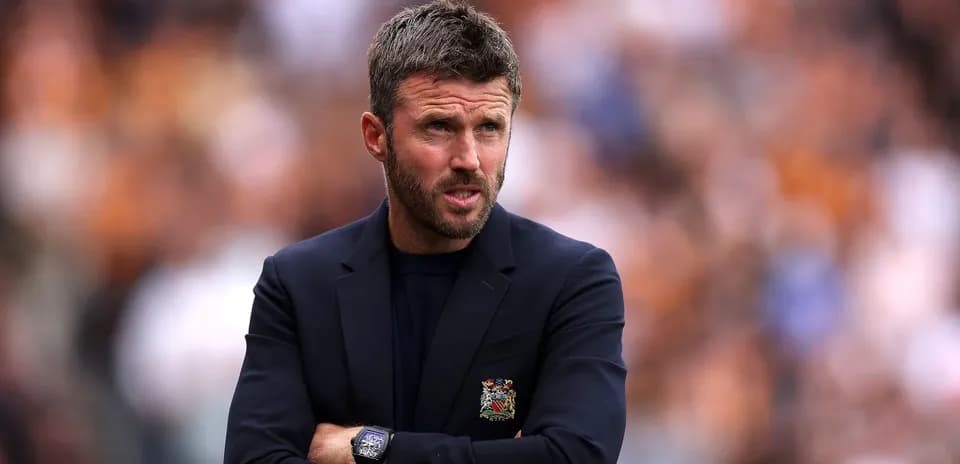 Manager observing the game with arms crossed