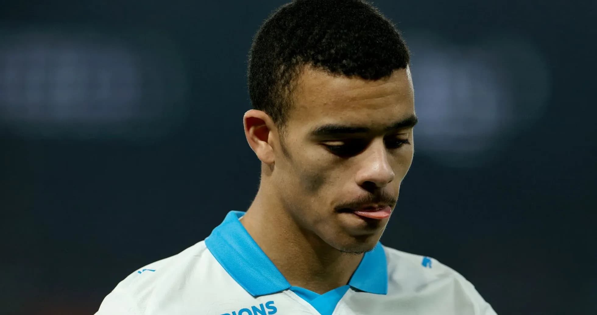 Player in white jersey looking down during match