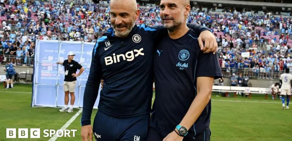 Two football coaches celebrating on the pitch