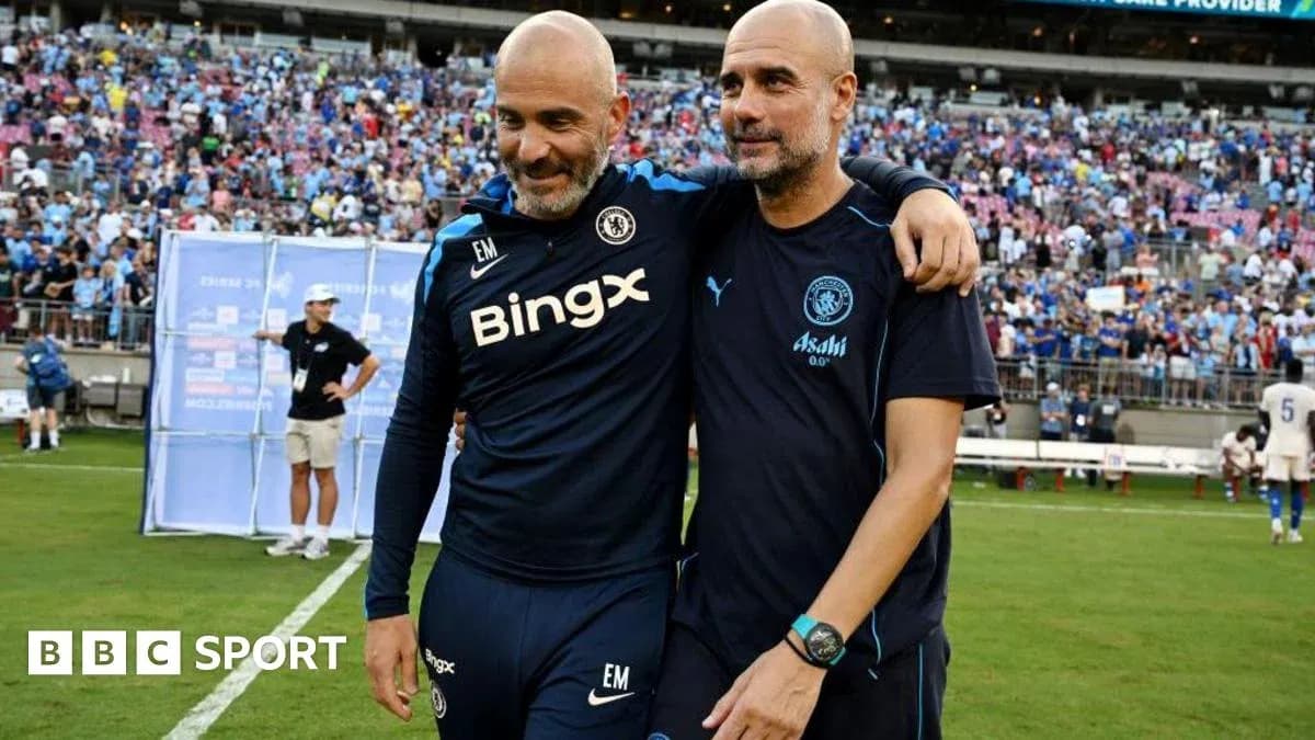 Two football coaches celebrating on the pitch