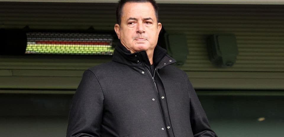 Man in black coat standing in stadium box