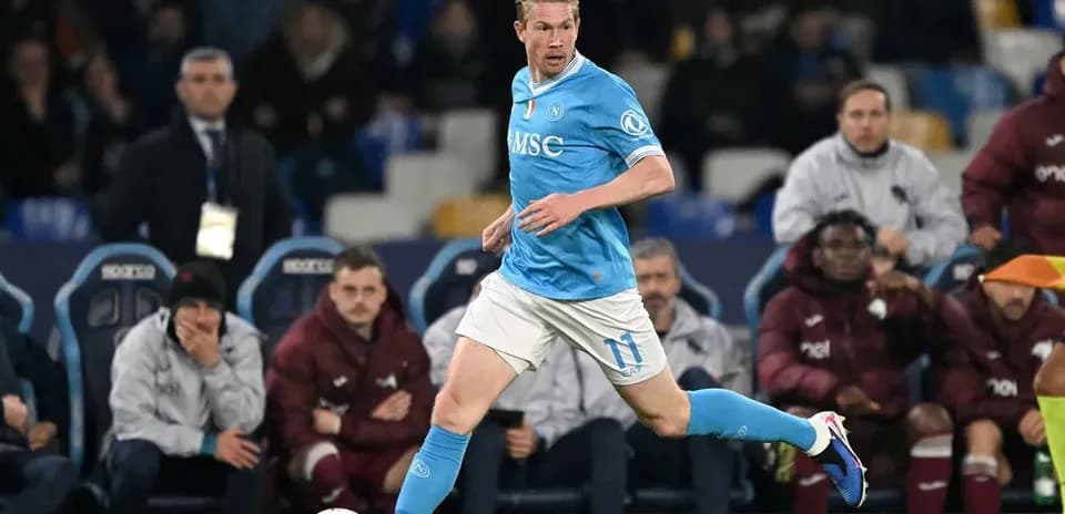 Player in blue kit running with ball on pitch