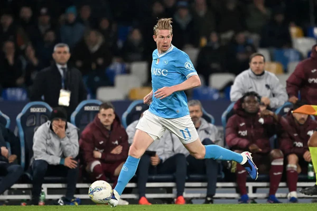 Player in blue kit running with ball on pitch