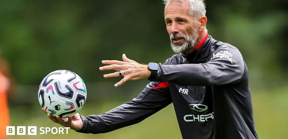 Coach demonstrating technique while holding a football