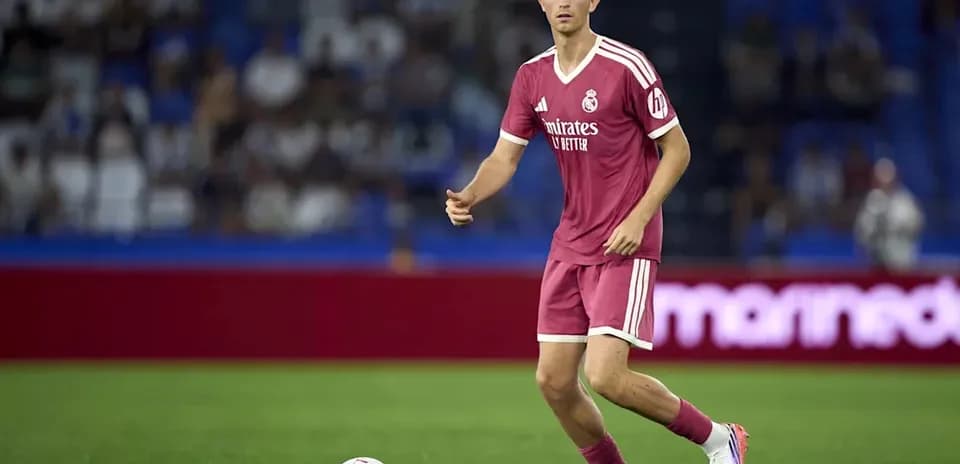 Player in pink jersey dribbling ball on field