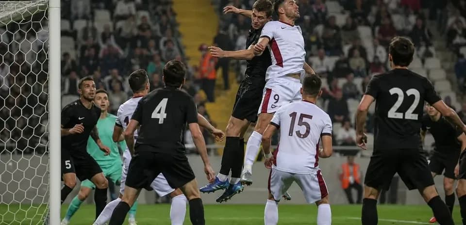 Players jumping for the ball near the goal