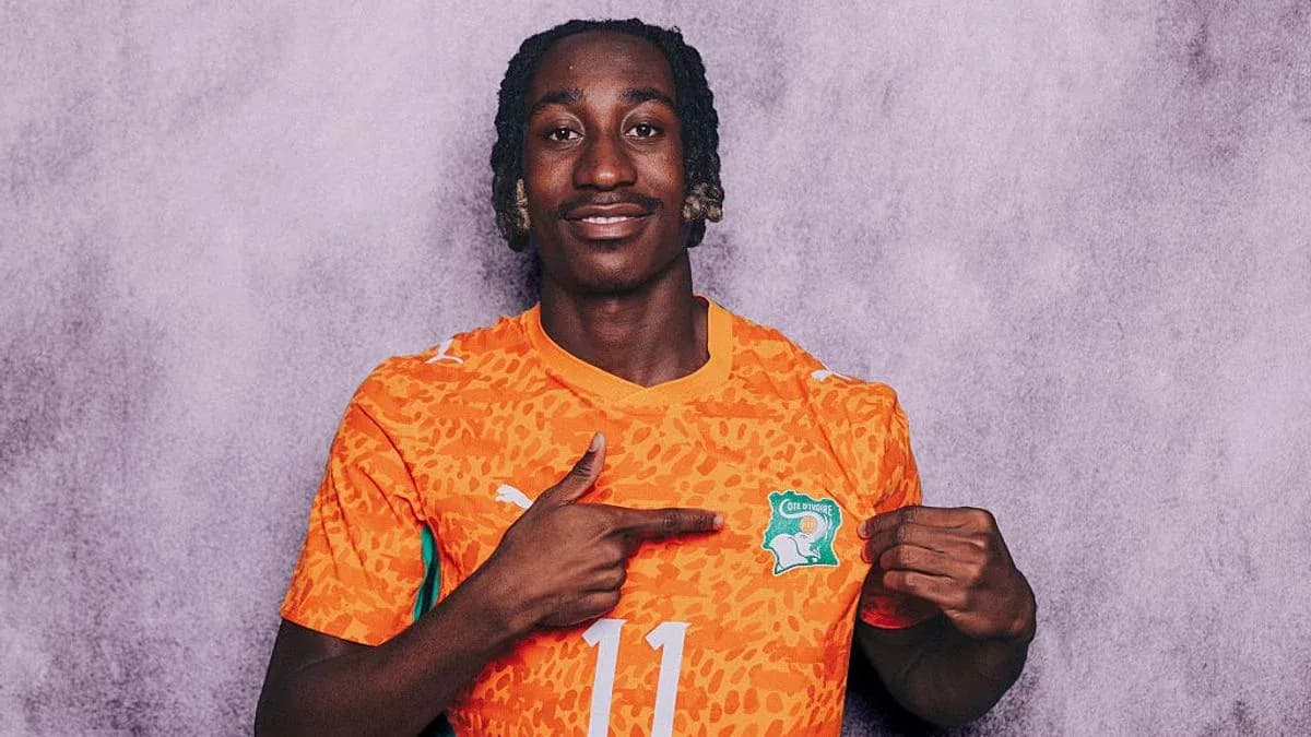 Player pointing at Côte d'Ivoire jersey emblem