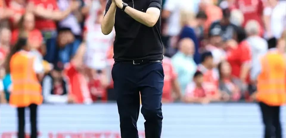 Coach applauding fans in stadium after match