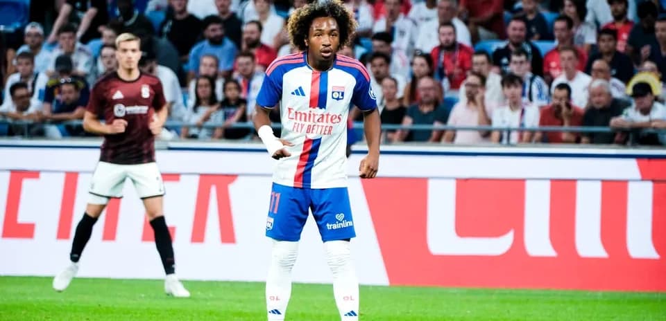 Player in OL kit during match with fans in background