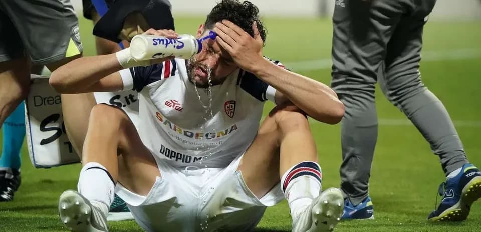 Player sitting on the ground pouring water on face