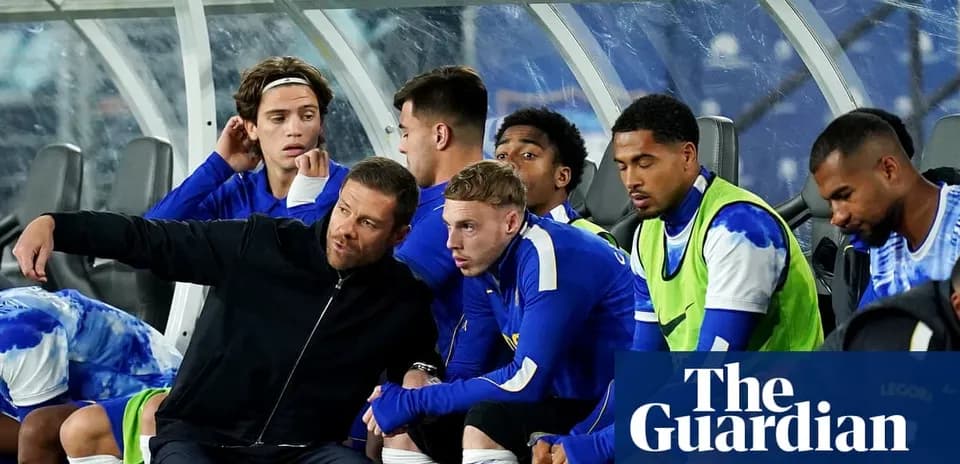 Coach discussing strategy with seated players on bench