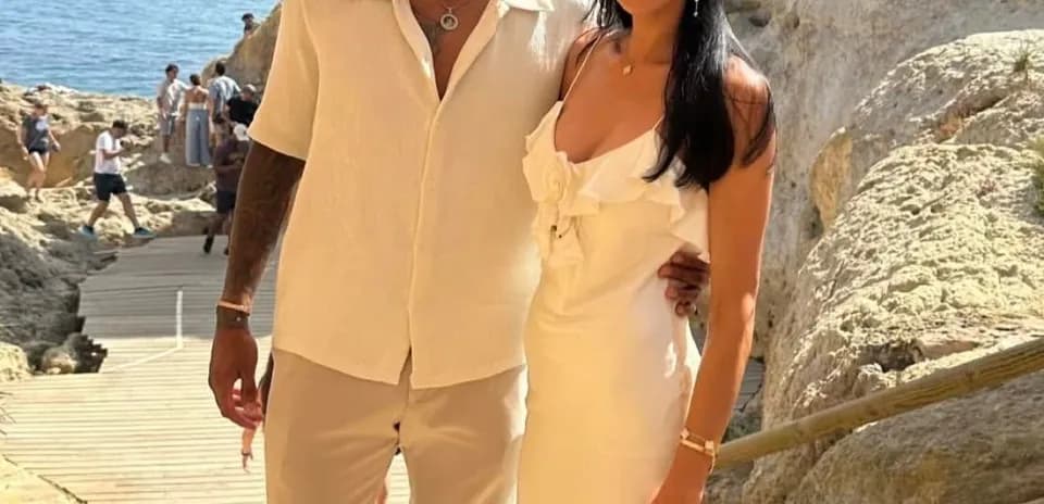 Couple posing together near rocky coastline