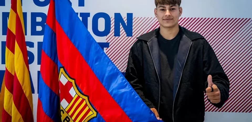 Young player holding FC Barcelona flag and smiling