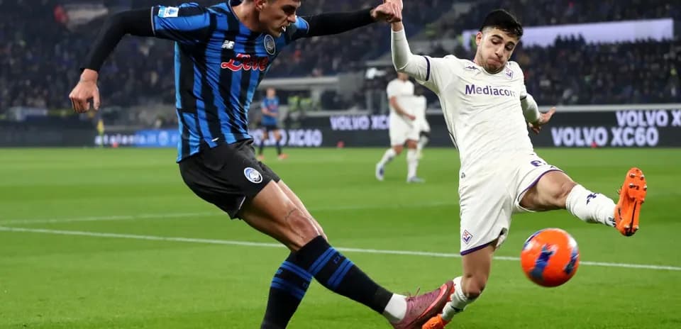 Fiorentina player tackling Atalanta opponent in match