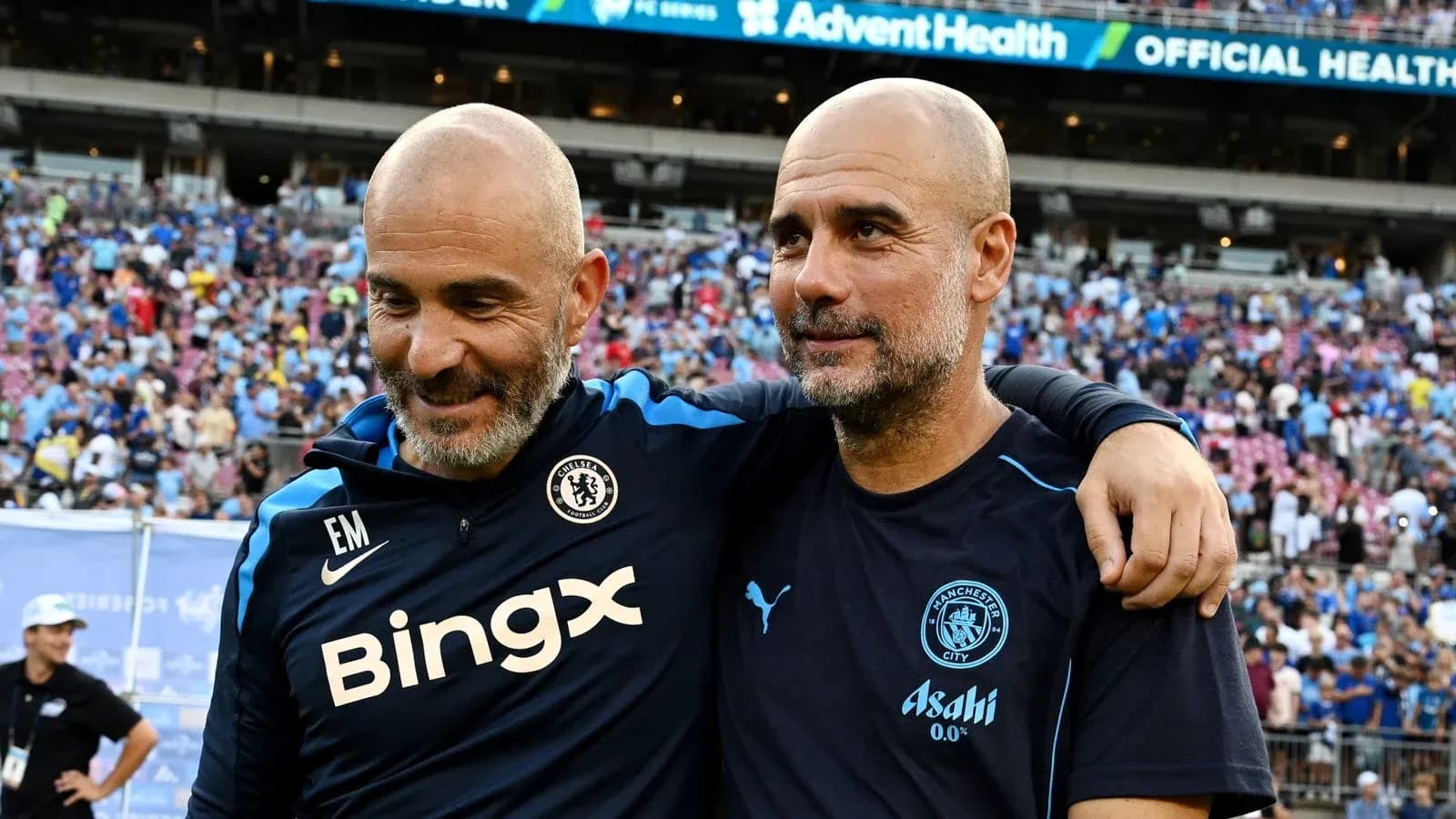 Two coaches smiling together after a match
