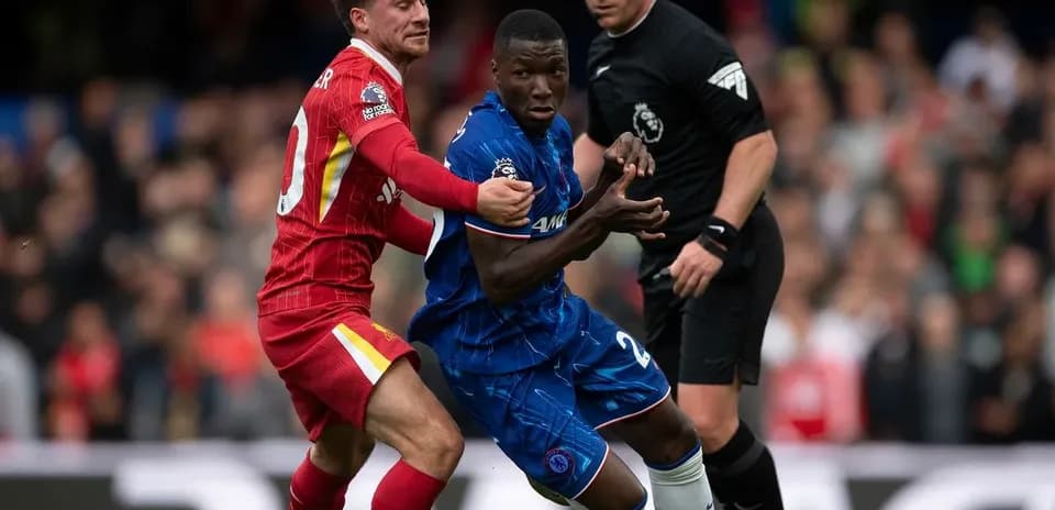 Liverpool player challenging Chelsea opponent during match
