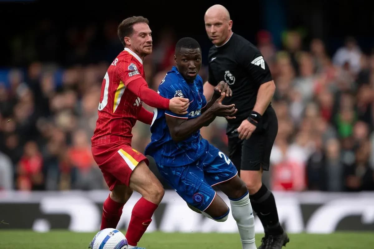 Liverpool player challenging Chelsea opponent during match