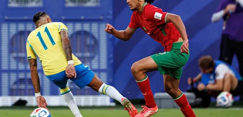 Brazilian player dribbling past Moroccan defender on pitch