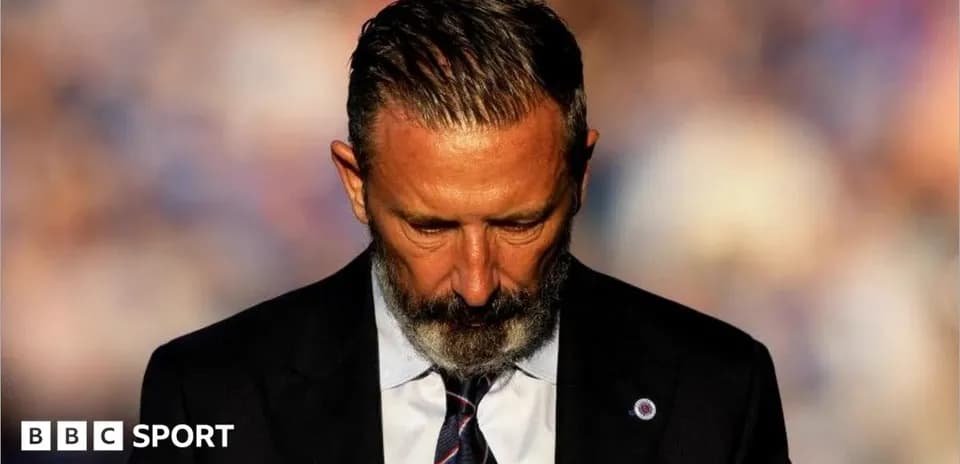 Coach with head bowed during press conference