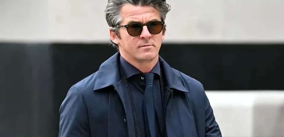 Man in sunglasses walking outdoors in formal attire