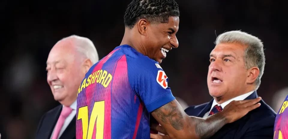 Player in Barcelona jersey smiling with officials