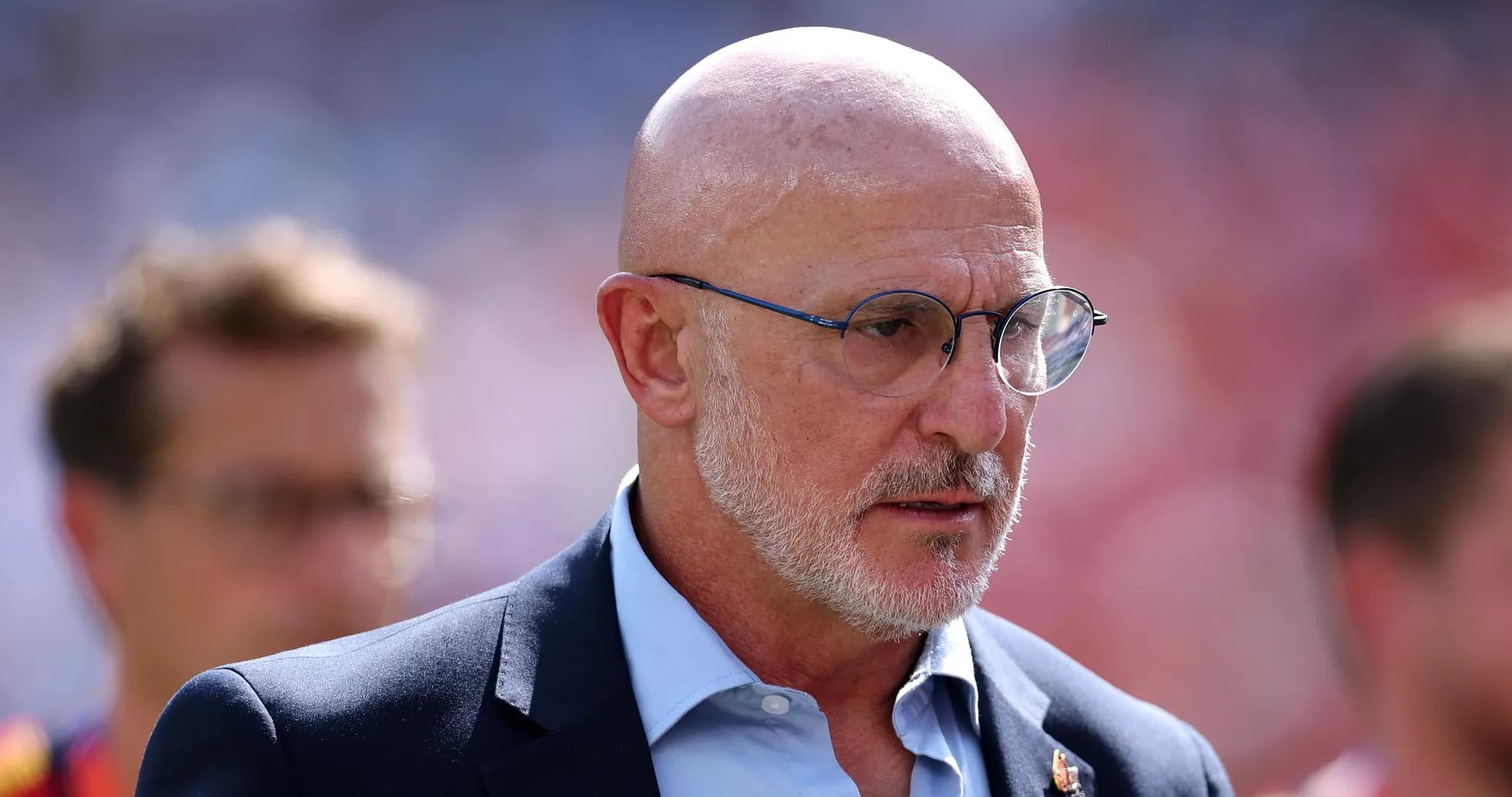 Man in suit with glasses on sports field