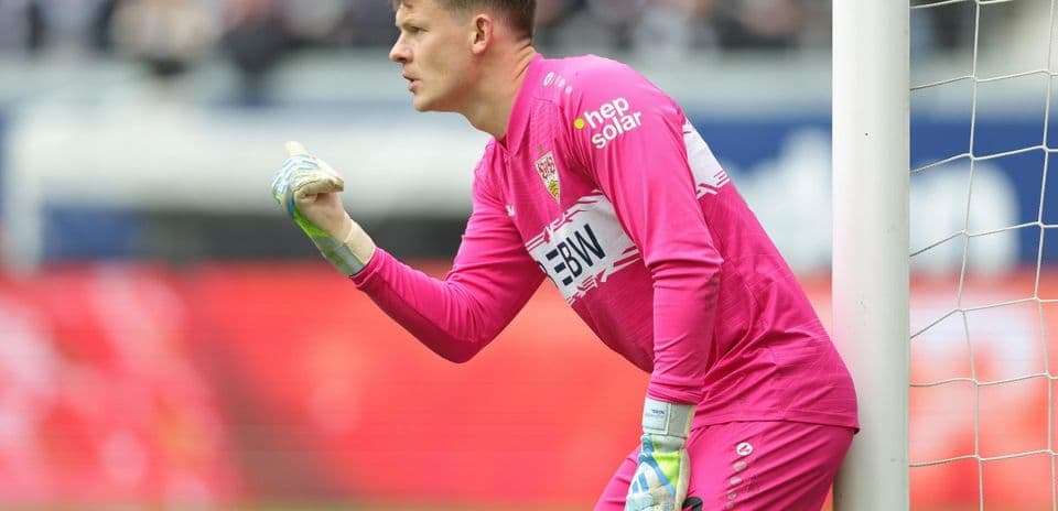 Goalkeeper in pink uniform directing teammates during match