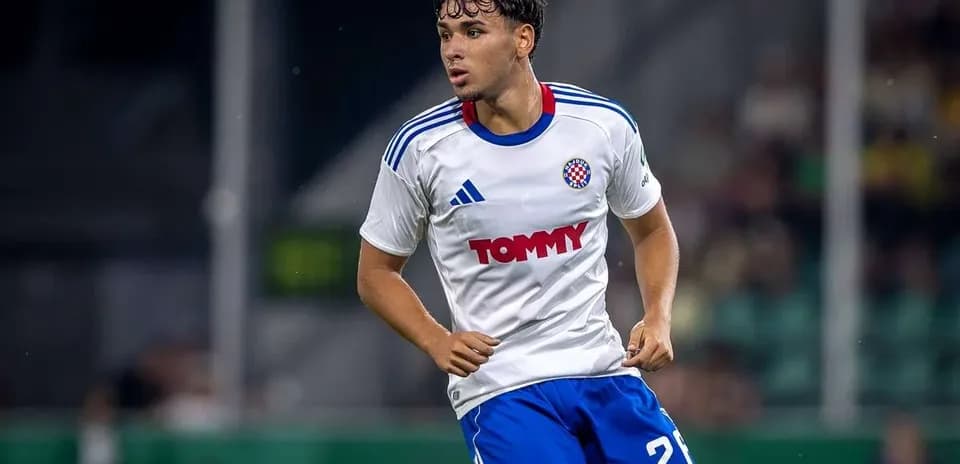 Player in white and blue kit running on field