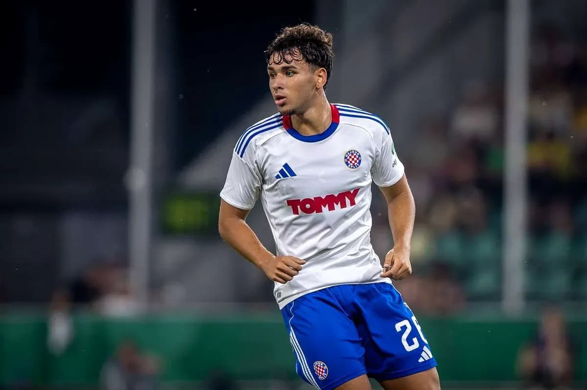 Player in white and blue kit running on field