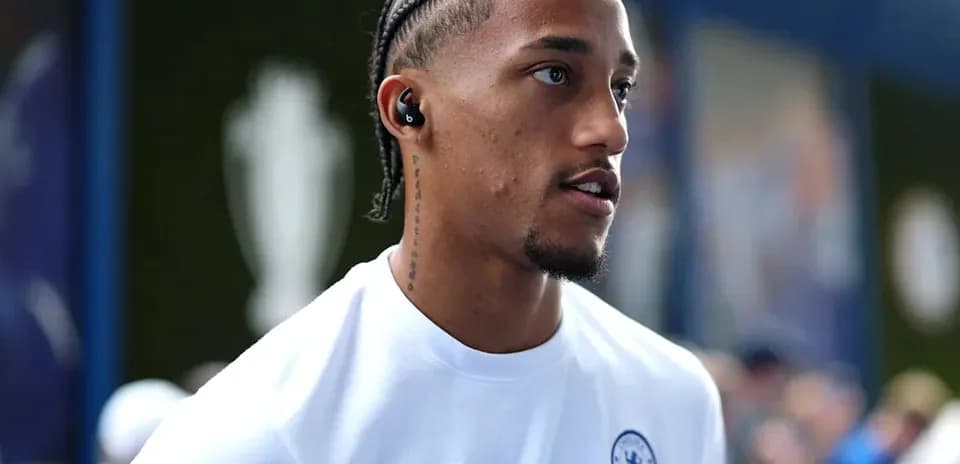 Player wearing Chelsea jersey with headphones