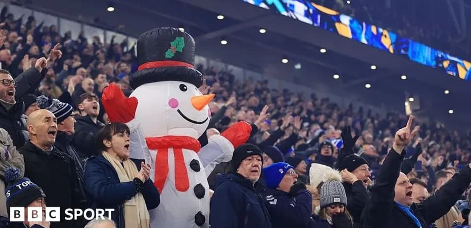 Fans cheering with a large inflatable snowman