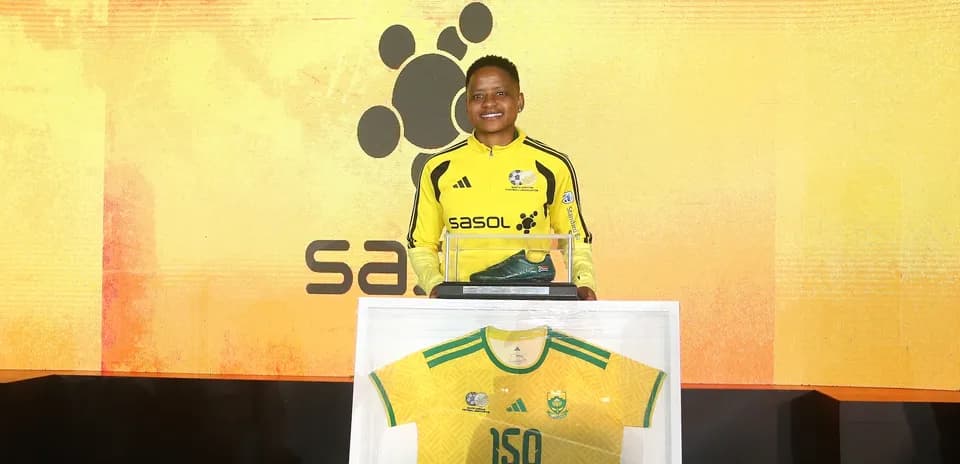 Player holding a shoe and jersey at event