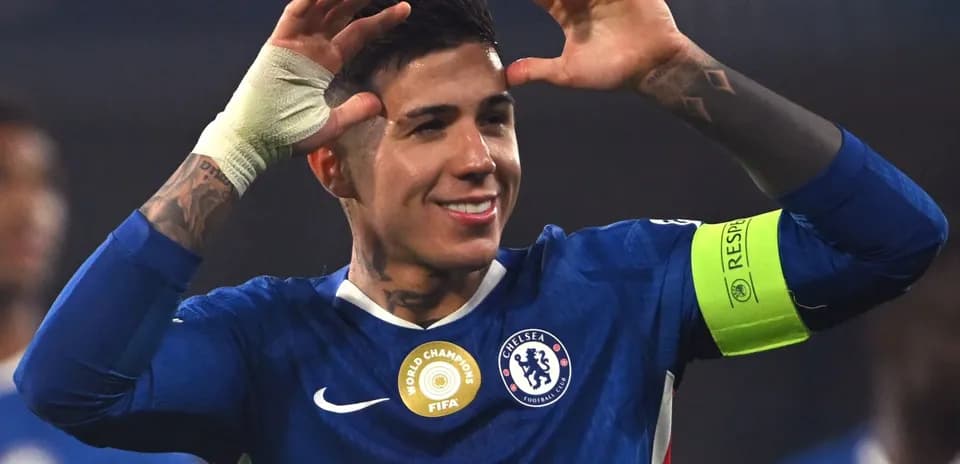 Player celebrating with hands raised in Chelsea kit
