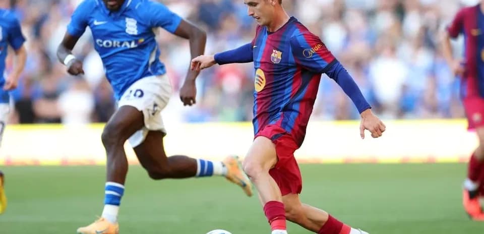 Barcelona player dribbling past Birmingham defender during match
