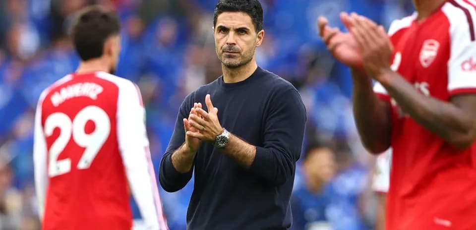Arsenal manager clapping with players in background