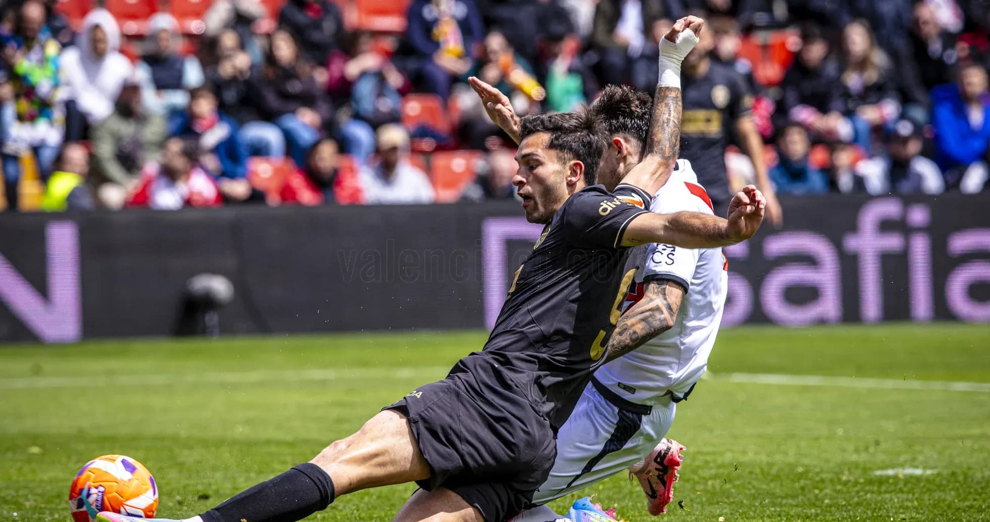 Valencia player tackling Rayo Vallecano opponent