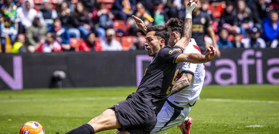 Valencia player tackling Rayo Vallecano opponent