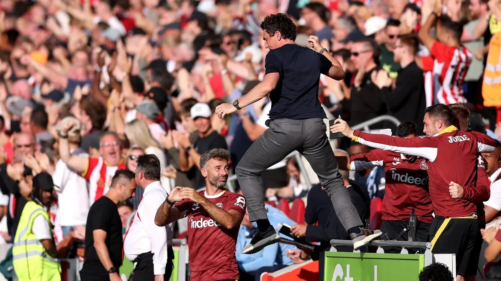 Coach celebrating with fans during match excitement