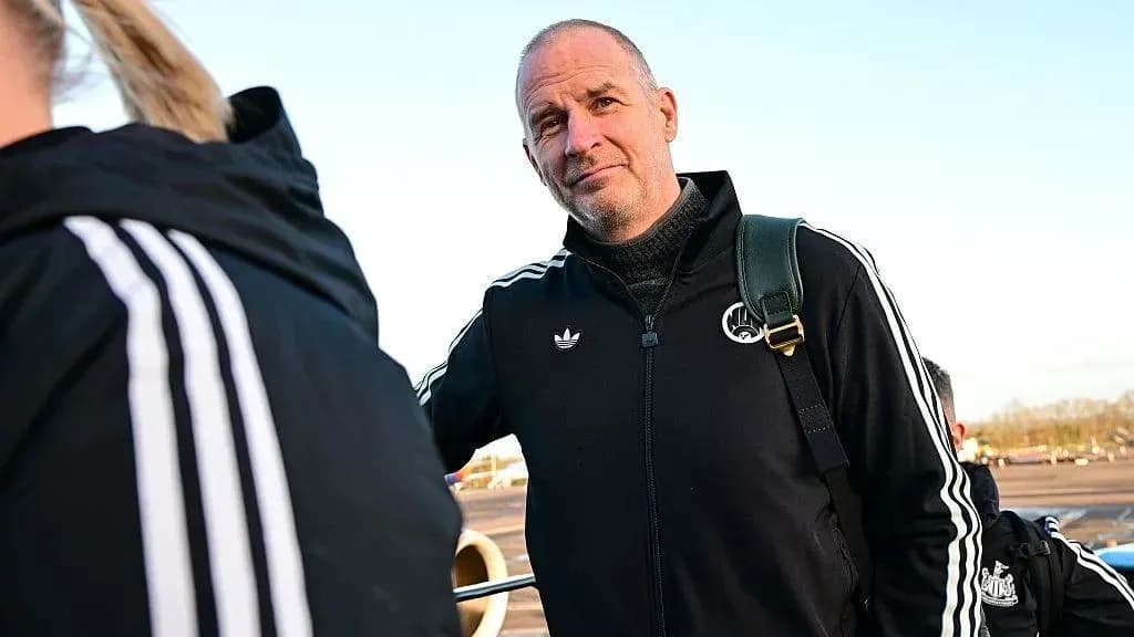 Coach in tracksuit at airport with team